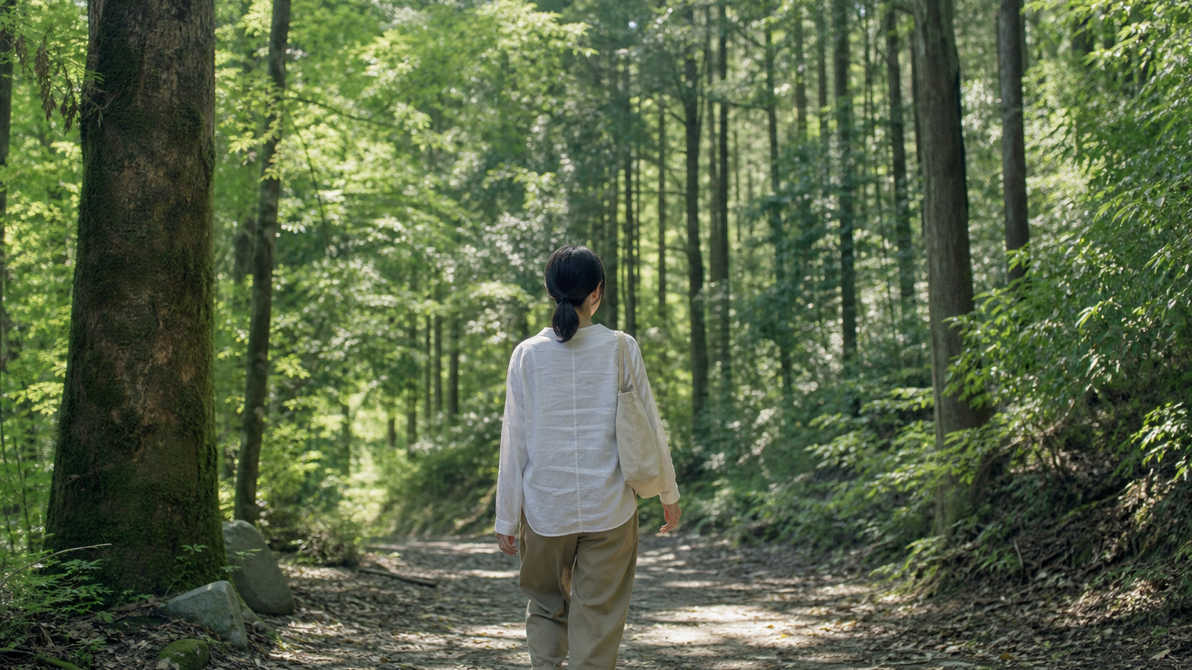 森の小道を歩き自然と向き合う女性