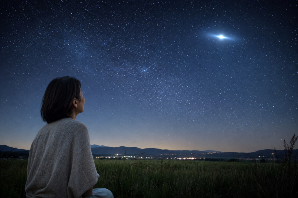 夜空の光を静かに観察する女性
