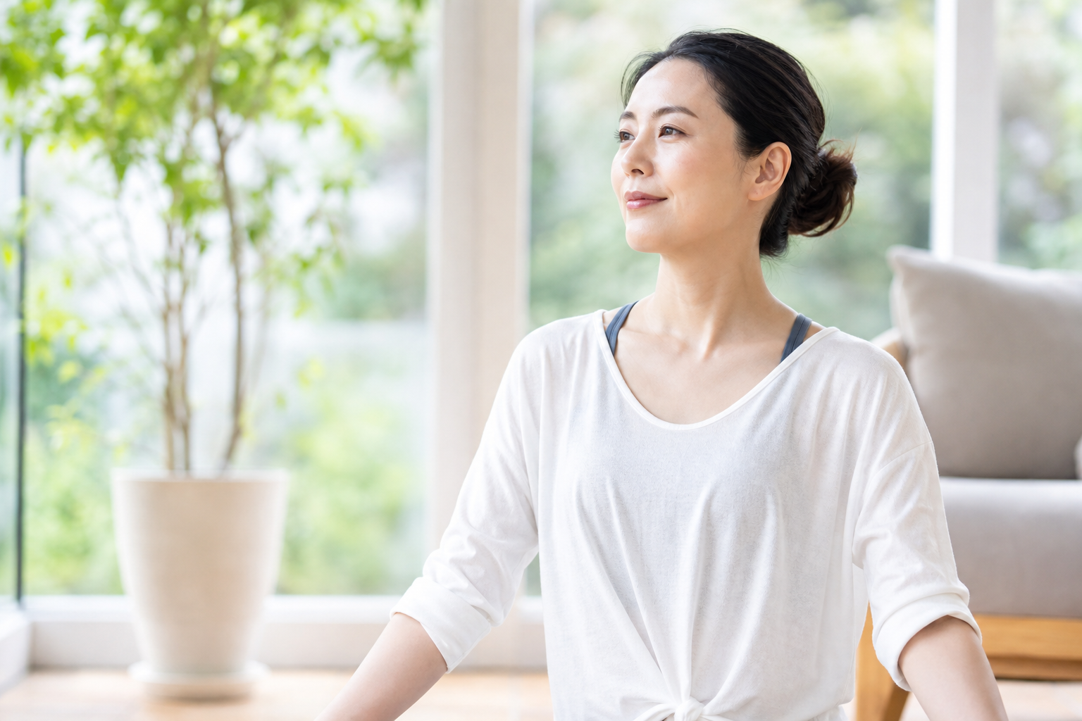 明るい部屋で呼吸に意識を向ける女性